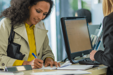 Image of a woman making a deposit at a bank for an article covering bank mystery shopping.