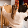 Image of a woman in a store comparing two sweaters for a post on how mystery shopping companies work.