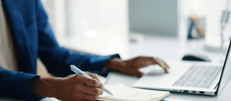 Image of a woman working on her laptop for an article covering how to write mystery shopping reports.