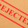 Image of a "Rejected" stamp on a cardboard background for a blog post discussing mystery shopping rejections.