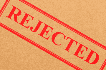 Image of a "Rejected" stamp on a cardboard background for a blog post discussing mystery shopping rejections.