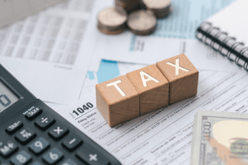 Image of wood block spelling the word "tax" for a blog post covering mystery shopping taxes.