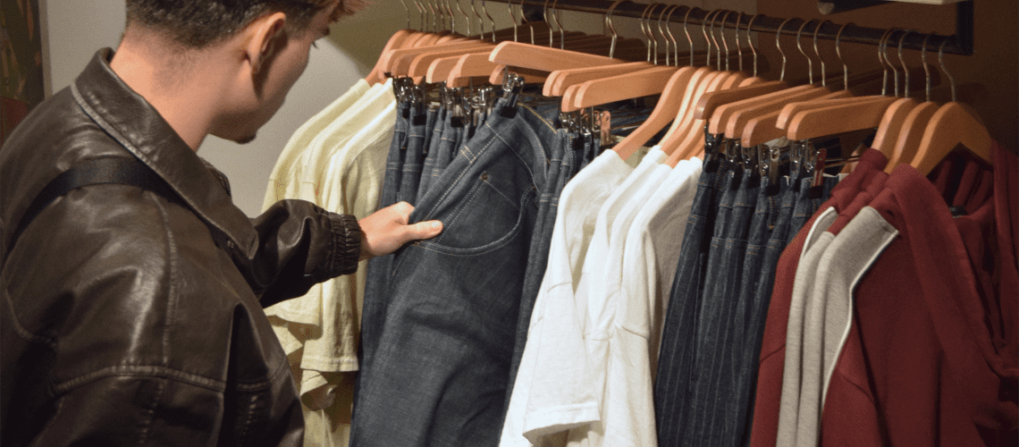 Image of a man looking at clothes in a store for a post about retail mystery shopping.