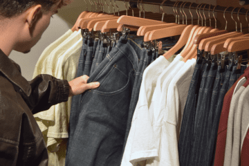 Image of a man looking at clothes in a store for a post about retail mystery shopping.