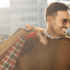 Image of a man outside of a shop with multiple bags for a post covering video mystery shopping.