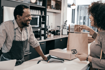 Image of a woman checking out during a shop for an article answering the question "what is mystery shipping?"