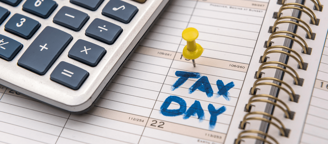 Image of a calculator and a calender marked "tax day" for a blog post covering the best tax software for mystery shoppers.