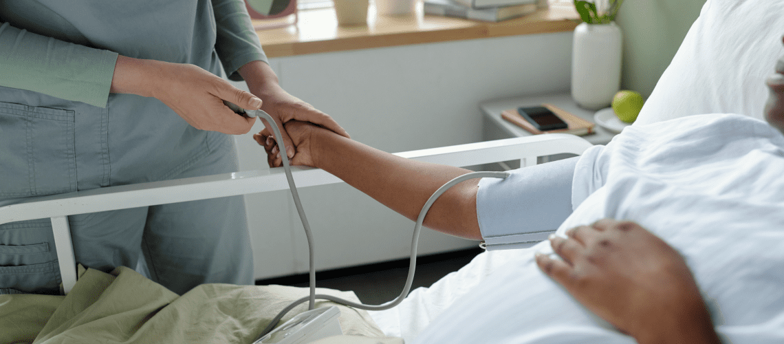 Image of a person in a hospital bed getting their blood pressure check for a post covering mystery shopping health insurance deductions.