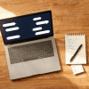 Image of AI mystery shopping reports workflow shown on a laptop next to handwritten shop notes and coffee on a warm wooden desk.