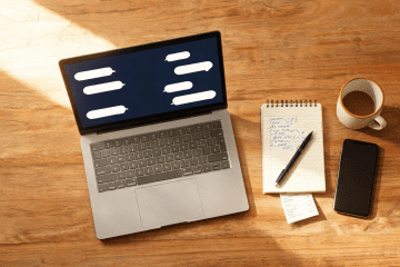 Image of AI mystery shopping reports workflow shown on a laptop next to handwritten shop notes and coffee on a warm wooden desk.