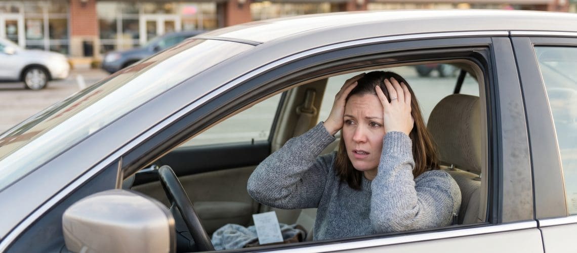 Image of a mystery shopper sitting in her car realizing she forgot something during a mystery shop