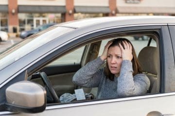 Image of a mystery shopper sitting in her car realizing she forgot something during a mystery shop