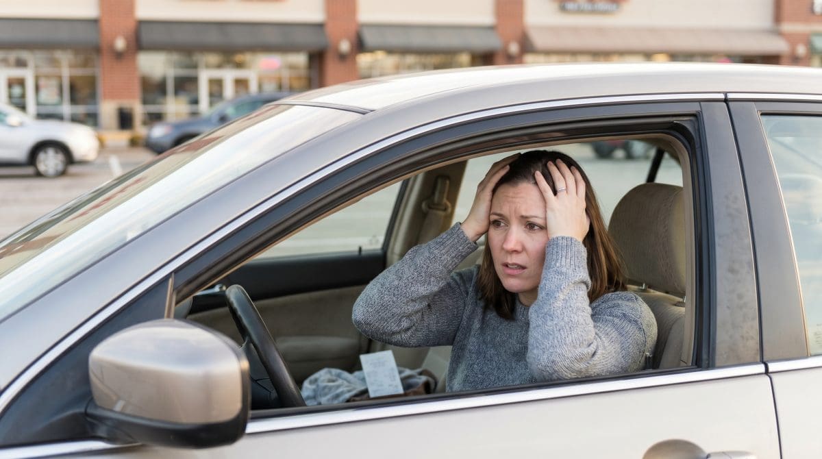 Image of a mystery shopper sitting in her car realizing she forgot something during a mystery shop